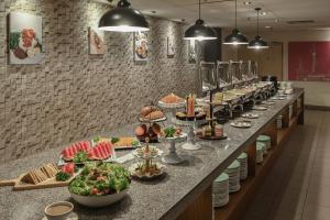 una línea de buffet con platos de comida. en Hotel Pudu Plaza Kuala Lumpur, en Kuala Lumpur