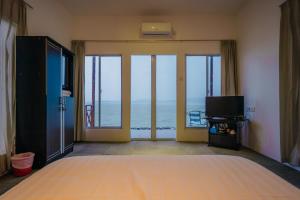 de Bintan Villa في Tenaga: غرفة نوم مع سرير وإطلالة على المحيط