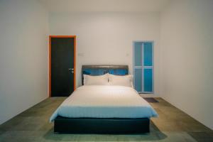 a large bed in a room with two windows at de Bintan Villa in Tenaga