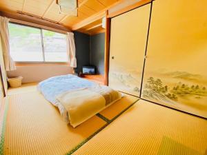 1 dormitorio con cama y ventana grande en Yamajuku Hanase-an - Vacation STAY 07897v, en Kawaguchi