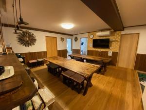 ein Esszimmer mit Holztischen und -stühlen in der Unterkunft Yamajuku Hanase-an - Vacation STAY 07897v in Kawaguchi