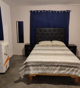 - une chambre avec un grand lit et un rideau bleu dans l'établissement Mi casa, à Ciudad Juárez