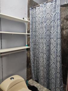 La salle de bains est pourvue d'un rideau de douche et de toilettes. dans l'établissement Mi casa, à Ciudad Juárez