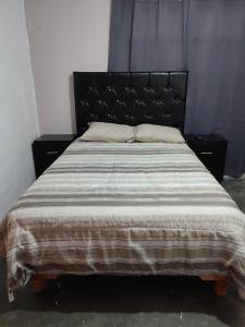 a bedroom with a large bed with a black headboard at Mi casa in Ciudad Juárez