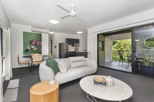 a living room with a couch and a table at NEW! 2BR Beachside Boutique Living in Townsville in Townsville