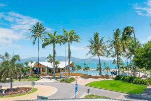 a resort with palm trees and the ocean at NEW! 2BR Beachside Boutique Living in Townsville in Townsville