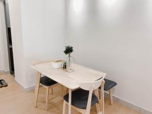 einen Tisch mit 2 Stühlen und einer weißen Wand in der Unterkunft Butter Theme 2Rooms Free Internet in Nilai