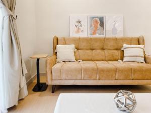 ein Wohnzimmer mit einem braunen Sofa und einem Tisch in der Unterkunft Butter Theme 2Rooms Free Internet in Nilai