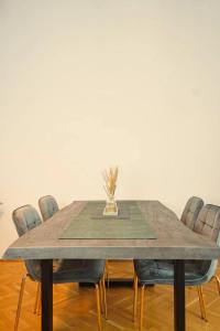 a dining room table with chairs and a vase on it at City Nook Apartments Near Hauptbahnhof in Vienna
