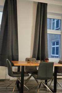 a dining room table with chairs and curtains at City Nook Apartments Near Hauptbahnhof in Vienna