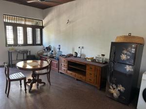 a kitchen with a table and a black refrigerator at Hotel 106 in Colombo