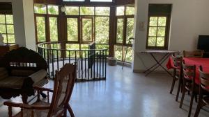 a room with chairs and a table and windows at Bellevue Retreat in Kandy