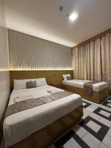 ein Hotelzimmer mit 2 Betten und einem Fenster in der Unterkunft Bamboo Garden Bussiness Inn in Dipolog City