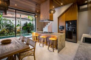 a kitchen with a counter and a table and chairs at Villa Sessun by Alfred in Bali in Canggu