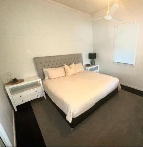 a bedroom with a white bed and a window at Cottage on the Bay 