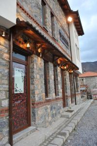 a stone building with a door on the side of it at Arolithos-Kaimaktsalan in Palaios Agios Athanasios