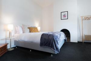 1 dormitorio con 1 cama grande y chimenea en Gorgeous on Gleadow: The Twin, en Invermay