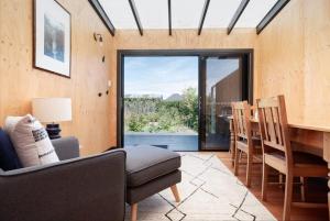 a living room with a couch and a table and chairs at Gorgeous on Gleadow: The Twin in Invermay