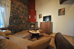 a living room with a table and a fireplace at Arolithos-Kaimaktsalan in Palaios Agios Athanasios