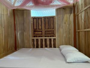 Bett in einem Zimmer mit Fenster und Fenster in der Unterkunft Homestay TonyLuận in Phú Thọ