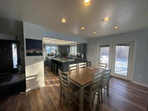 uma cozinha e sala de jantar com uma mesa de madeira e cadeiras em Hidden Lakefront Villa em Fairbanks