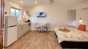 坎納馬拉的住宿－Cunnamulla Tourist Park，一间卧室配有一张床,厨房配有桌子