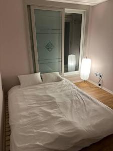 białe łóżko w pokoju z oknem w obiekcie Jinistay #Netflix #Oceanview #private barbeque facility #1pm checkout w mieście Ulsan