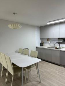 uma cozinha com uma mesa branca e cadeiras em Jinistay #Netflix #Oceanview #private barbeque facility #1pm checkout em Ulsan