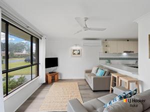 Una sala de estar con un sofá y un televisor en Casa al Mare, en Iluka