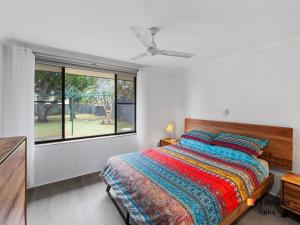 Un dormitorio con una cama grande y una ventana en Casa al Mare, en Iluka