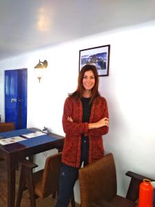 a woman standing in front of a table at El Ave Azul Boutique Hotel Cusco in Cusco