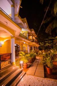 a large house with a porch at night at Primavera Holiday Homes in Candolim