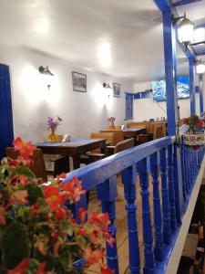 a restaurant with tables and chairs and a blue railing at El Ave Azul Boutique Hotel Cusco in Cusco