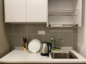 uma bancada de cozinha com um lavatório e um lavatório em Family 2 Rooms w/t Internet Nilai Youth City A07 em Nilai