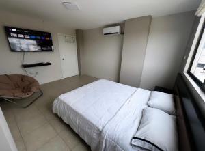 een slaapkamer met een wit bed en een raam bij CRUCITA BEACH KP in Crucita