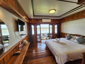 Suksomboonhotel في لووي: غرفة نوم بسرير كبير وتلفزيون فيها