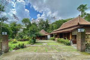 ein Haus mit einem Innenhof davor in der Unterkunft Pondok Pakde Villa by TwoSpaces, Jogja in Soprayan
