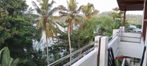 a view of palm trees from a balcony of a house at The Green Lagoon Villa in Hikkaduwa