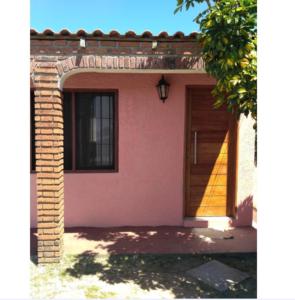 a pink house with a door and a window at Lo de Sandra in Costa Azul