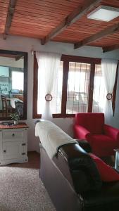 salon z kanapą i czerwonym krzesłem w obiekcie Lo de Sandra w mieście Costa Azul