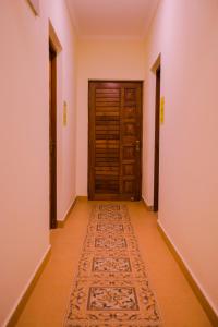 an empty corridor with a door and a rug at Primavera Holiday Homes in Candolim