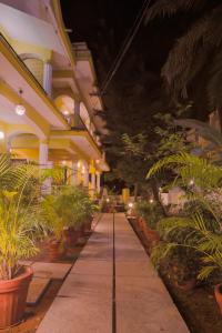 a walkway in a building with plants at Primavera Holiday Homes in Candolim