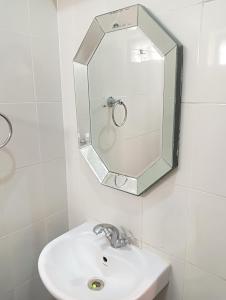 La salle de bains est pourvue d'un lavabo et d'un miroir mural. dans l'établissement Smiley Resorts, à Auroville