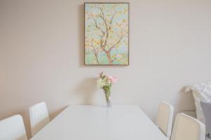 a white table with a vase of flowers on it at The most comfortable and best choice for accommodation in Yoyogi SioY5 in Tokyo