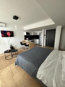 una camera con un grande letto e una cucina di Exclusivo Monoambientes a Estrenar, Amenities Premium, Cochera Opcional, Inmejorable Ubicación a 200 metros del Mar, Depto OCEANA a Mar del Plata