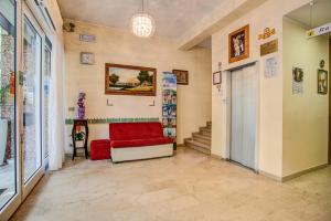 a living room with a red couch and stairs at Hotel Tiziana in Rimini
