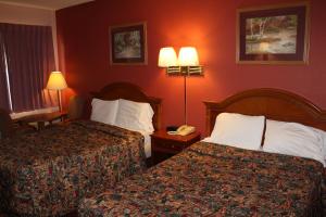 two beds in a hotel room with red walls at Andrew Johnson Inn in Greeneville