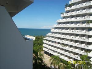 a large white building with the ocean in the background at Jomtien Condotel Condominium in Pattaya South