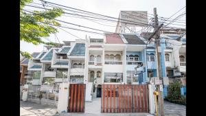 a white and blue house with a gate in front of it at 168 House 4A4B 350m BTS Krungton Buri near Icon Siam in Godown