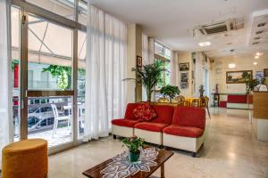 a living room with a red couch and a table at Hotel Tiziana in Rimini